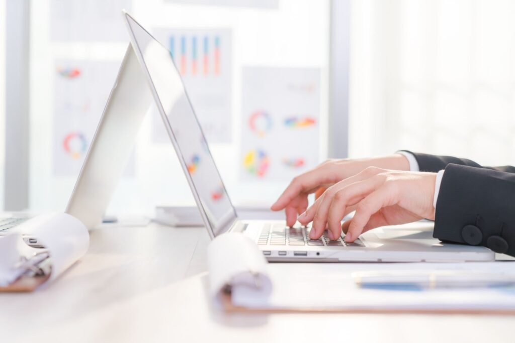 Closeup of business woman hand typing on laptop keyboard