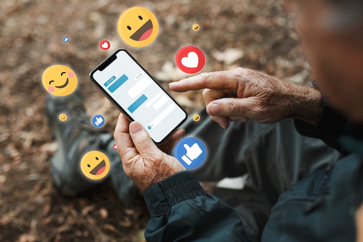 an old man sitting on a bench holding a smartphone, with virtual emojis around it